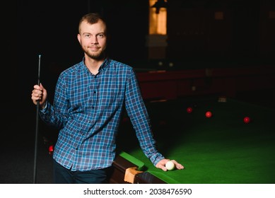 Young Man Playing Billiards In The Dark Billiard Club