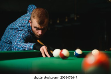 Young Man Playing Billiards In The Dark Billiard Club