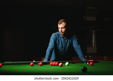 Young Man Playing Billiards In The Dark Billiard Club