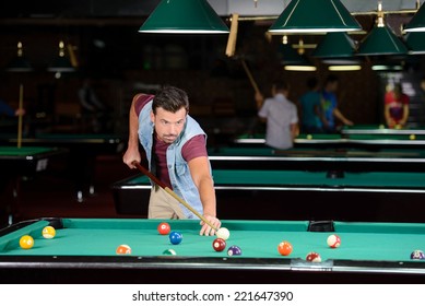 Young Man Playing Billiards In The Dark Billiard Club