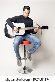 Young Man Playing Black Acoustic Guitar On The White Background