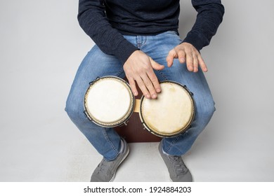 Young Man Playing Bongos On The White Background