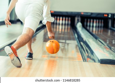 Young man playing bowling at the sport club.