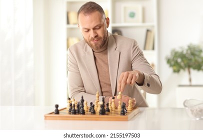 Young Man Playing Chess Alone At Home