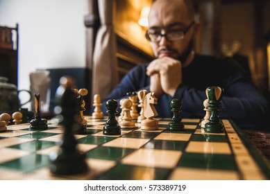 a young man playing chess sitting in cafe