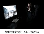 Young man playing computer games in dark room