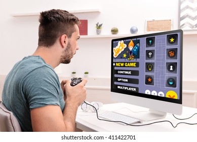 Young Man Playing Computer Games At Home