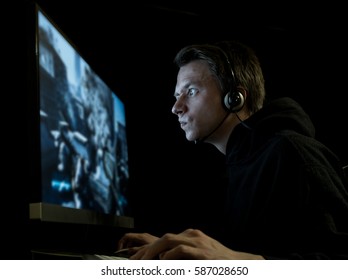 Young Man Playing Computer Games In Dark Room