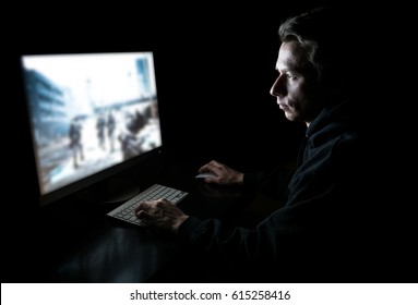 Young Man Playing Computer Games In Dark Room