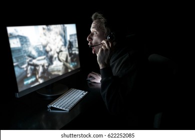 Young Man Playing Computer Games In Dark Room