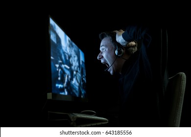 Young Man Playing Computer Games In Dark Room