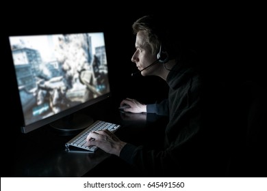 Young Man Playing Computer Games In Dark Room