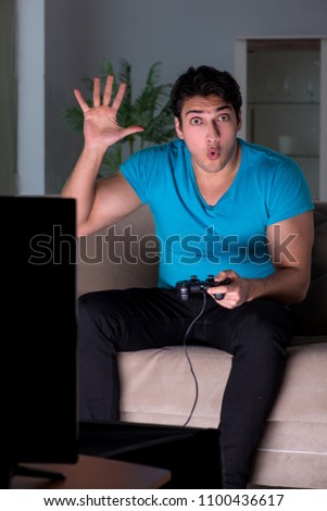 Young man playing computer games late at night