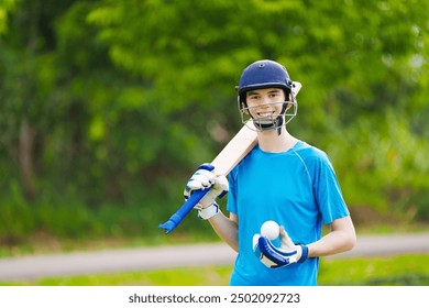 Young man playing cricket in summer park. Teenager with bat and ball on cricket pitch. Helmet and guard for safe game. Sport for active fit male. Cricket club in college. Sports activity and exercise. - Powered by Shutterstock