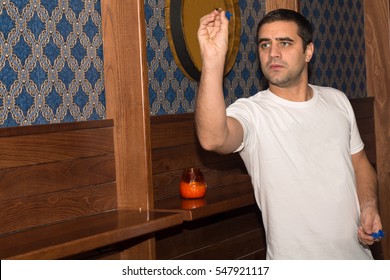 Young Man Playing Darts In A Club