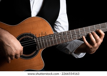 Young man playing the guitar. Classic guitar. Guitarist playing classical guitar. handsome man holding guitar