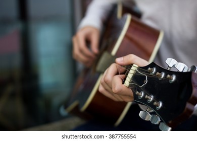 Young Man Playing Guitar. Close Up. Focus On The Left Hand. With Shallow Depth Of Field.