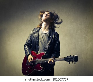 Young Man Playing The Guitar And Headbanging