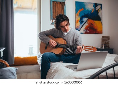 Young Man Playing Guitar In His Room