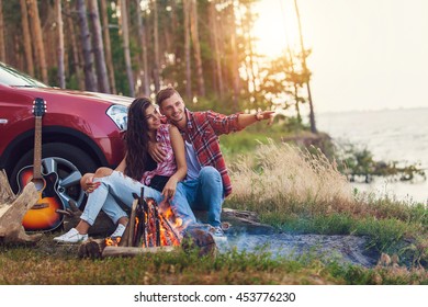 young man playing guitar for his girlfriend on a road trip - Powered by Shutterstock