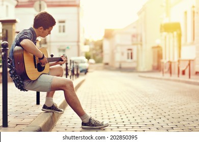 Young Man Playing On Acoustic Guitar - Outdoor