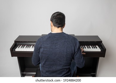 young man playing piano on the white background