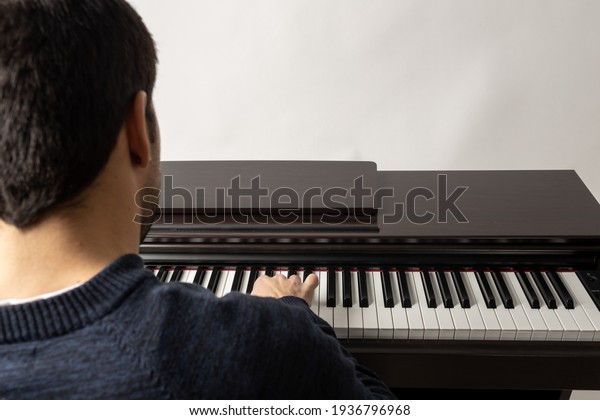 young man\
playing piano on the white\
background