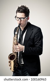 Young Man Playing Sax On Gray Background