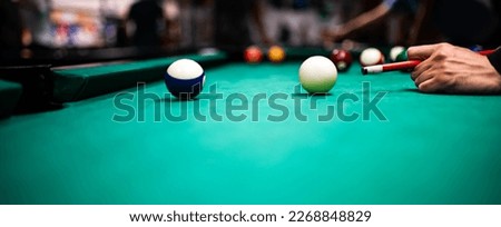 Young man playing snooker, aiming. for a good shot
