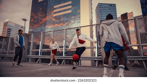 Young Man Playing Soccer with Diverse Friends. Multiethnic Stylish Group Enjoying a Game of Football at an Urban Parking Lot on Rooftop with Skyscrapers at Sunset. African Player Scoring a Goal - Powered by Shutterstock