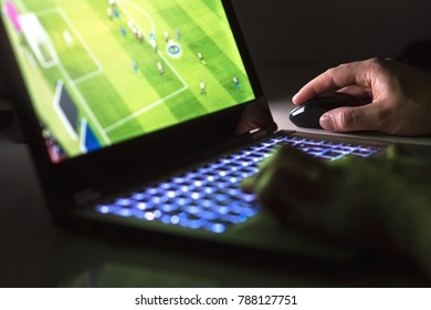 Young Man Playing Soccer Or Football Game Online With Laptop In Dark Or Late At Night. Competitive Video Gaming, Electronic Sports And Esports Concept.