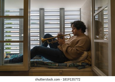 Young Man Playing Trumpet At Home