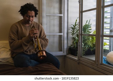 Young Man Playing Trumpet At Home