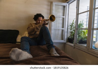 Young Man Playing Trumpet At Home