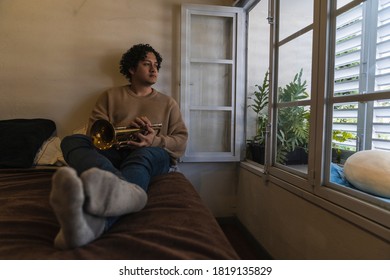 Young Man Playing Trumpet At Home