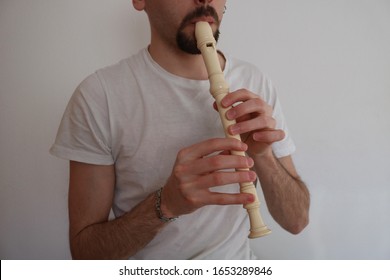 Young Man playing white Recorder - Powered by Shutterstock