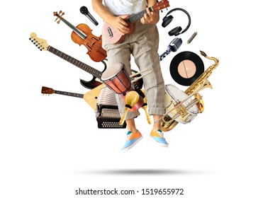 Young man plays guitar among musical instruments - Shutterstock ID 1519655972