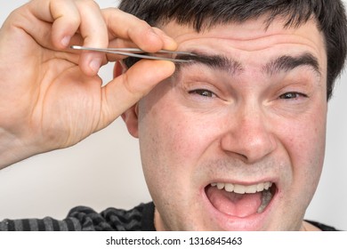 Young Man Is Plucking Eyebrows With Tweezers