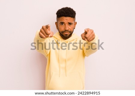 young  man pointing forward at camera with both fingers and angry expression, telling you to do your duty