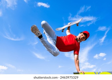 young man posing happy with skateboard in hand background blue and cloudy. youth sports and entertainment concept - Powered by Shutterstock - Get 15% off with code: PIKWIZARD15