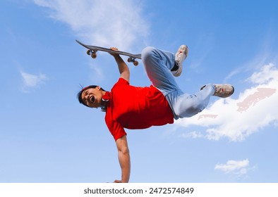 young man posing happy with skateboard in hand background blue and cloudy. youth sports and entertainment concept - Powered by Shutterstock