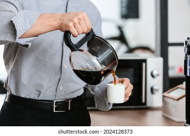 Young man pouring coffee into cup in office, closeup - Powered by Shutterstock