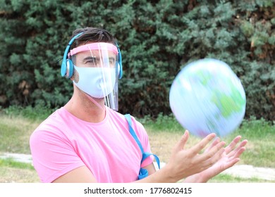 Young man with PPE playing with the globe 