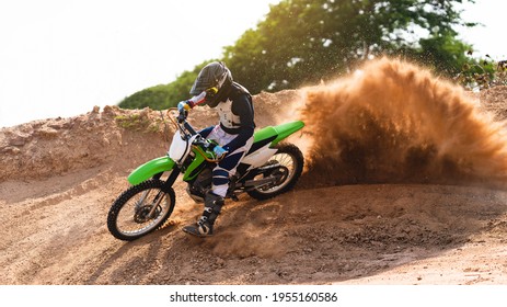 Young man practice riding dirt bike.Splashing sand