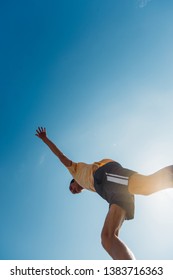 Young Man Practicing Parkour Exercise Below Blue Sky, Low Angle Shot