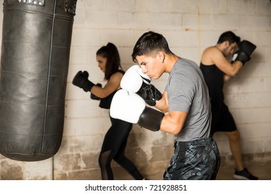 Young Man Practicing Some Boxing In Front Of A Punching Bag During A Boxing Class In A Gym