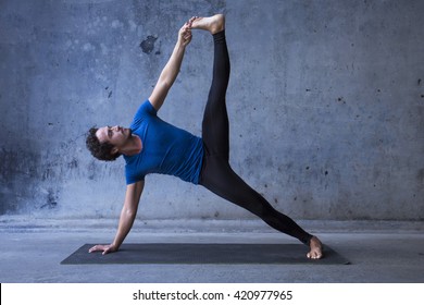 Young Man Practicing Yoga. Side Plank Pose, Vasisthasana In Sanskrit.