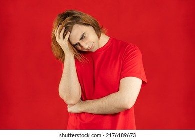 Young Man Prep Student With Long Hair. Portrait Of Depressing Guy. Red Background.