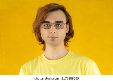 Young Man Prep Student With Long Hair. Portrait Of A Guy On A Yellow Background.