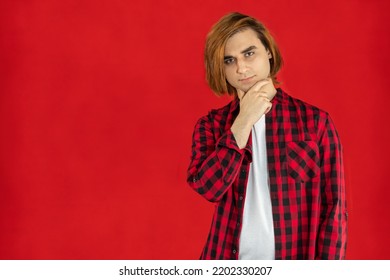 Young Man Prep Student With Long Hair. Portrait Of A Guy With Hand On Chin. Red Background.